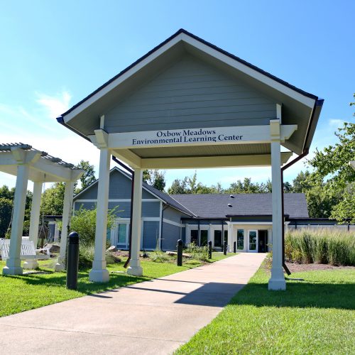 an overhang with a sign that says Oxbow Meadows Environmental Learning Center