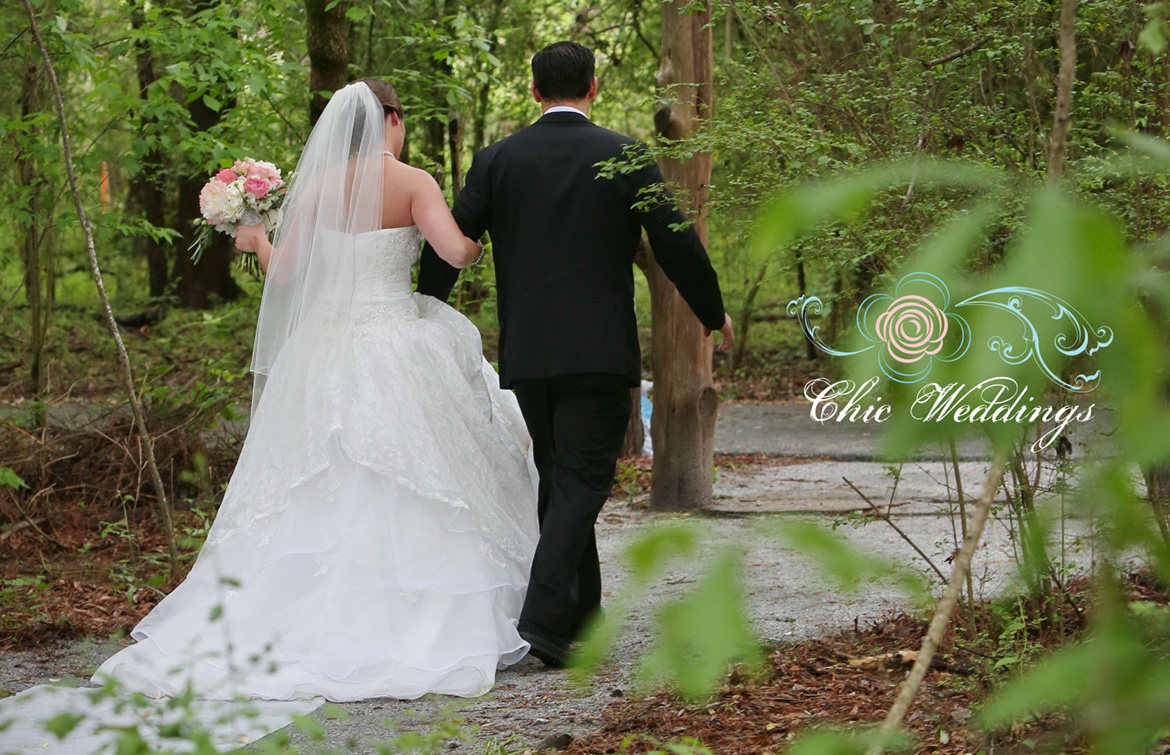 a man and a woman in a wedding dress walking through the woods
