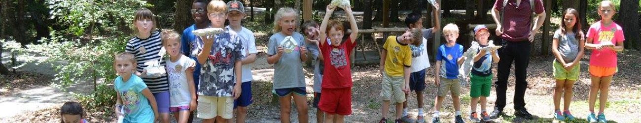 several children posing in front of a stream