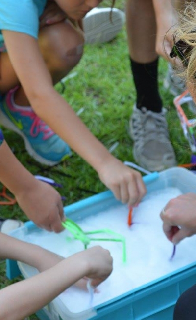 several children dipping wands into bubbles