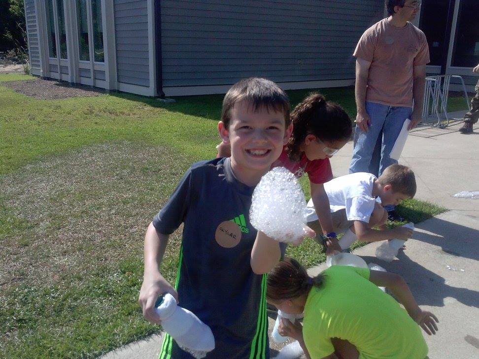 a boy holding soap bubbles