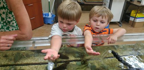 two children holding something from an exhibit