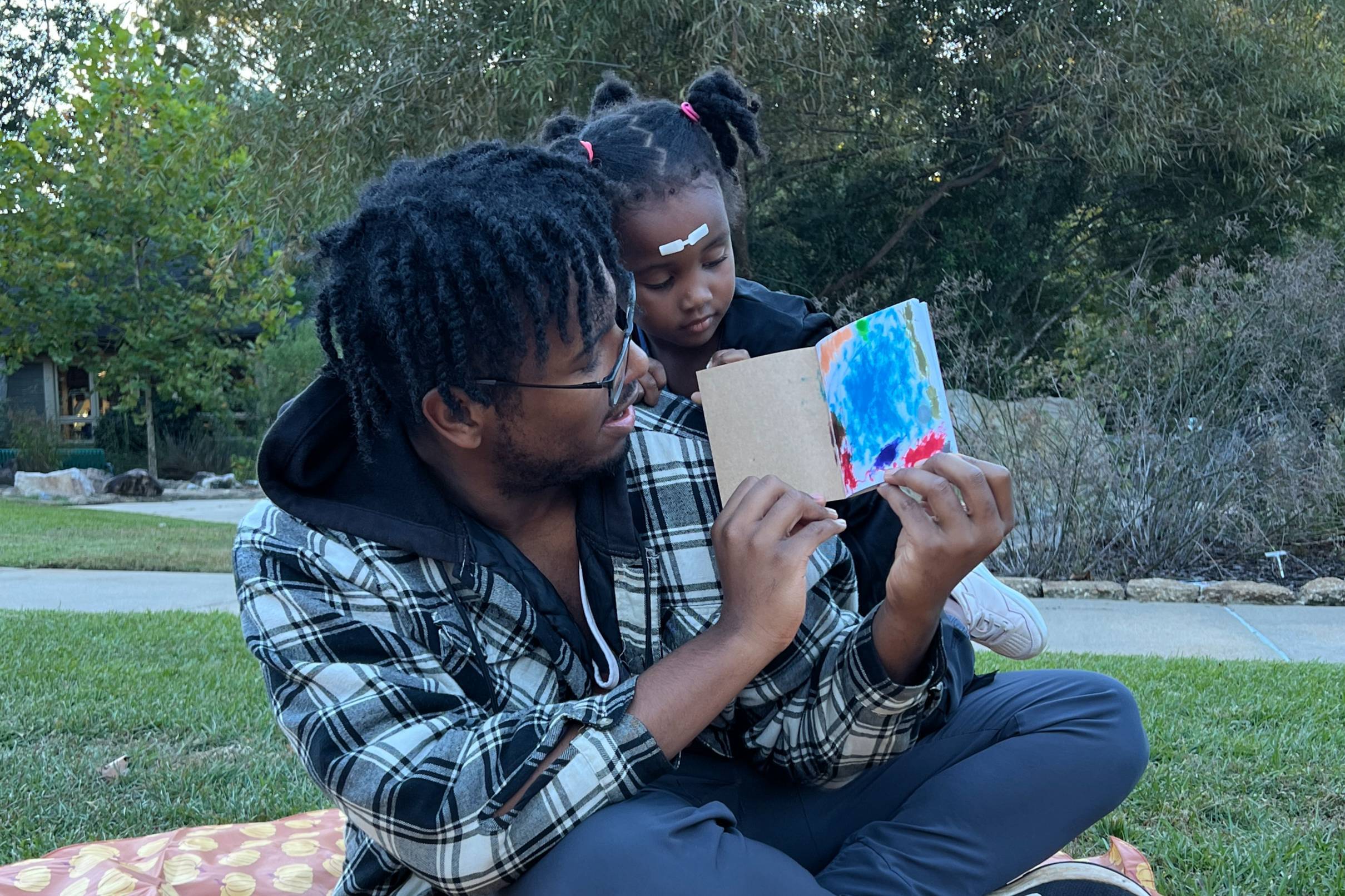 Man and child looking at notebook