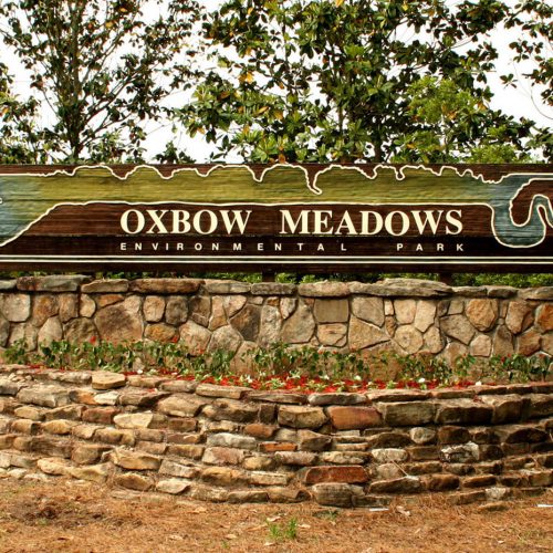 a large sign that says Oxbow Meadows Environmental Park