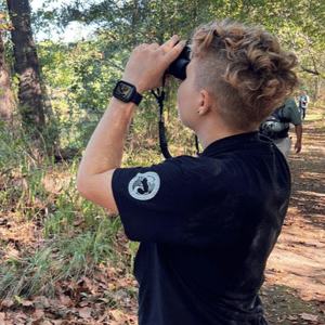 Adult birdwatching with binoculars in the woods. Adult birdwatching with binoculars in the woods.