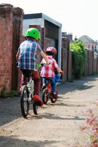 two children riding bicycles