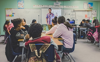 children sitting in a classroom listening to a lecture