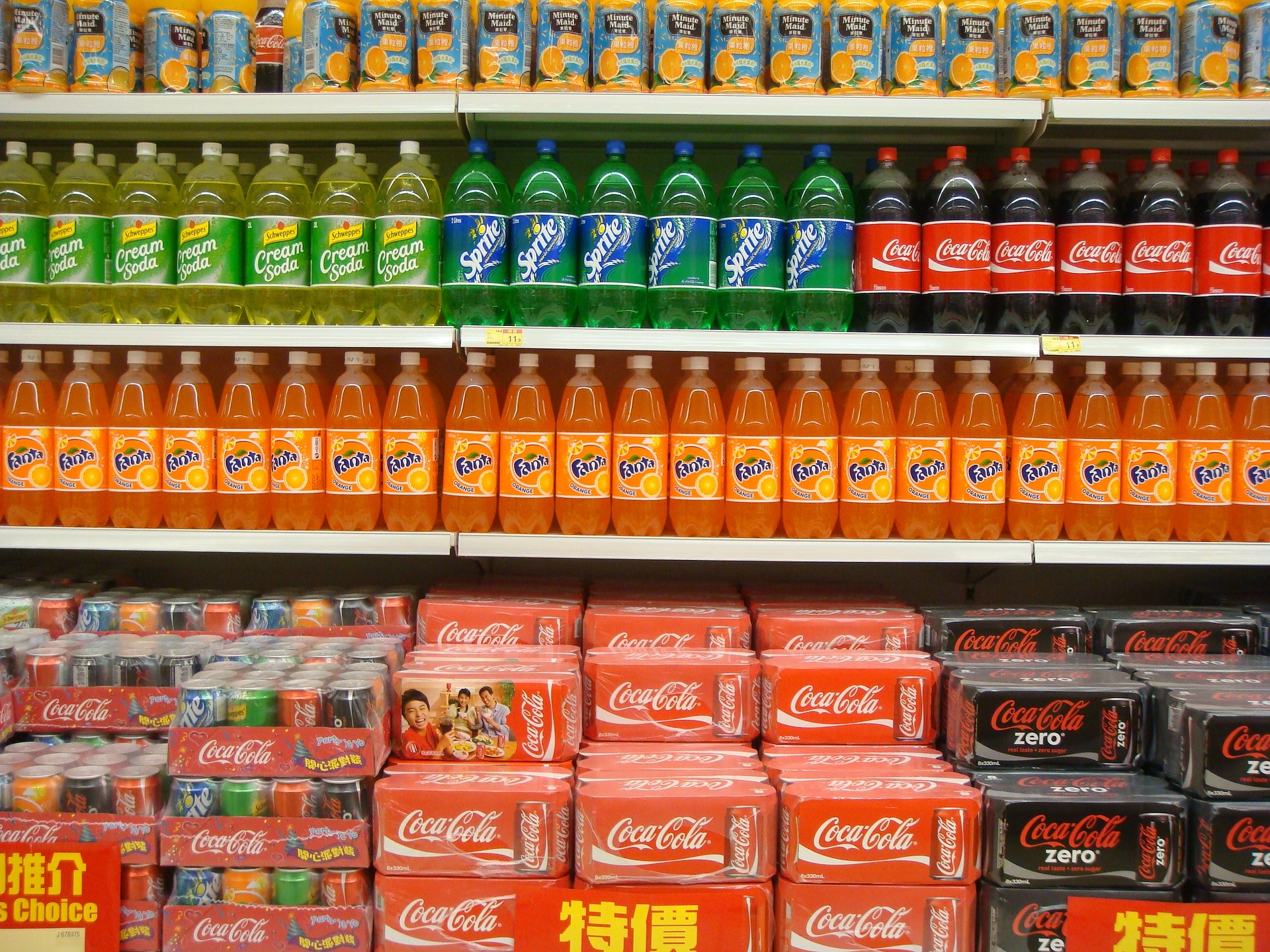 a shelf of soda bottles and cans