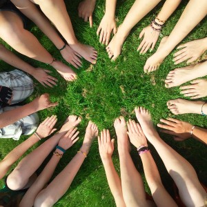 multiple people's arms and legs on grass