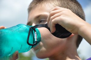 a boy drinking water from a bottle